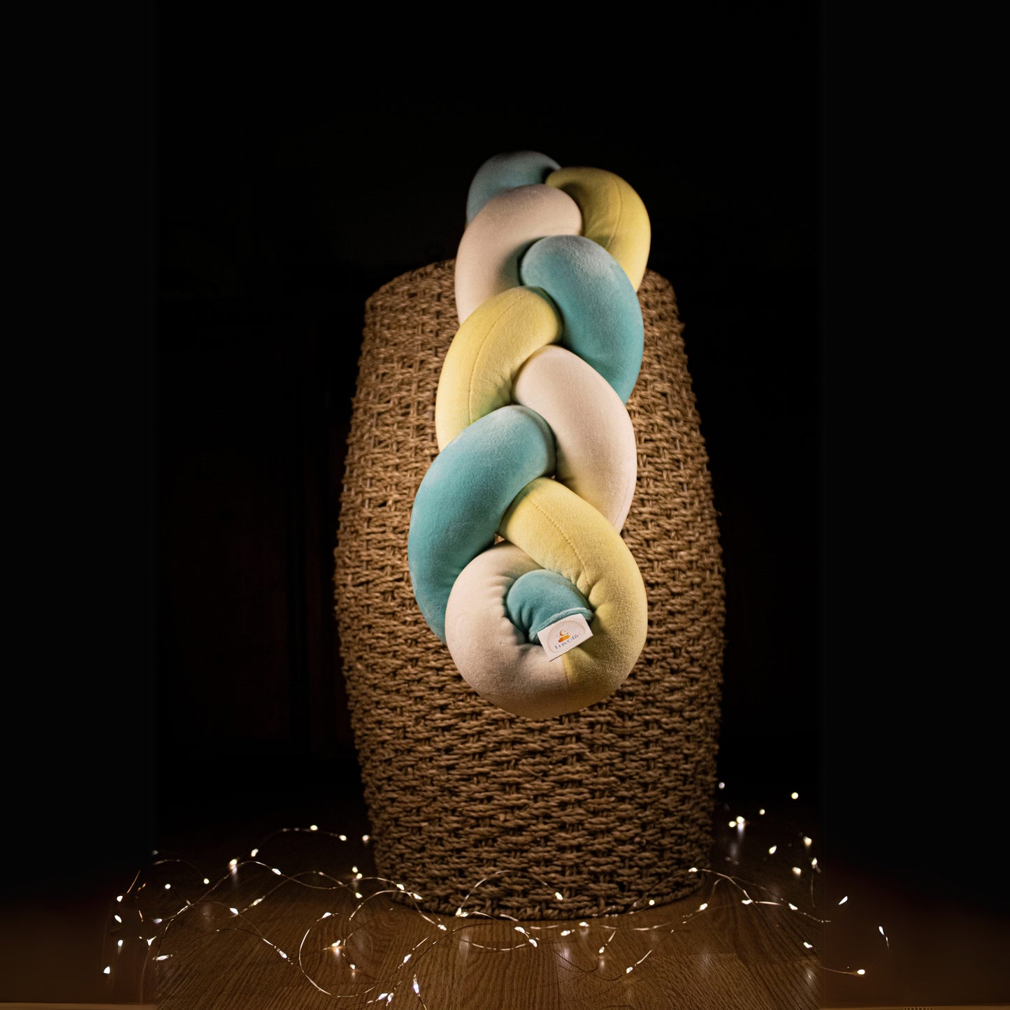Tresse de lit en velours Luvolie exposée dans un panier en osier avec lumières