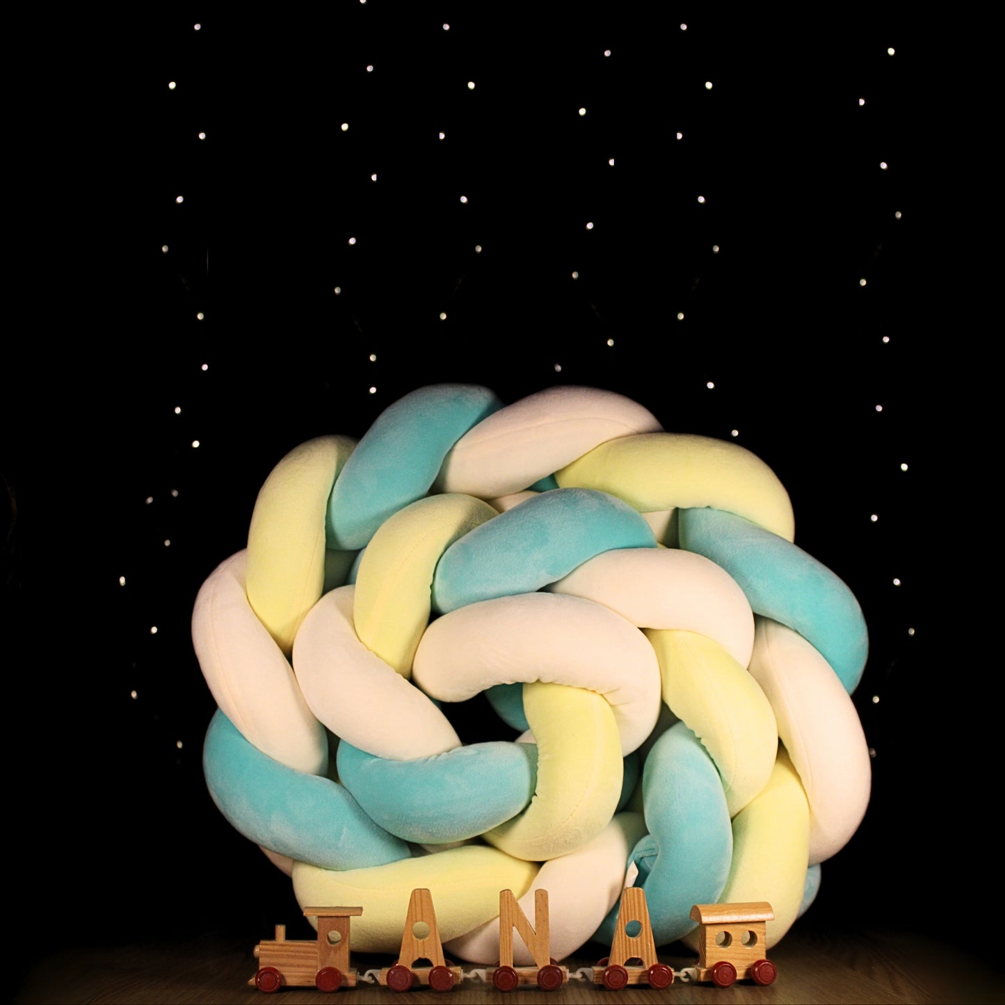 Tresse Luvolie roulée en boule, décorée avec lettres en bois sous un ciel étoilé